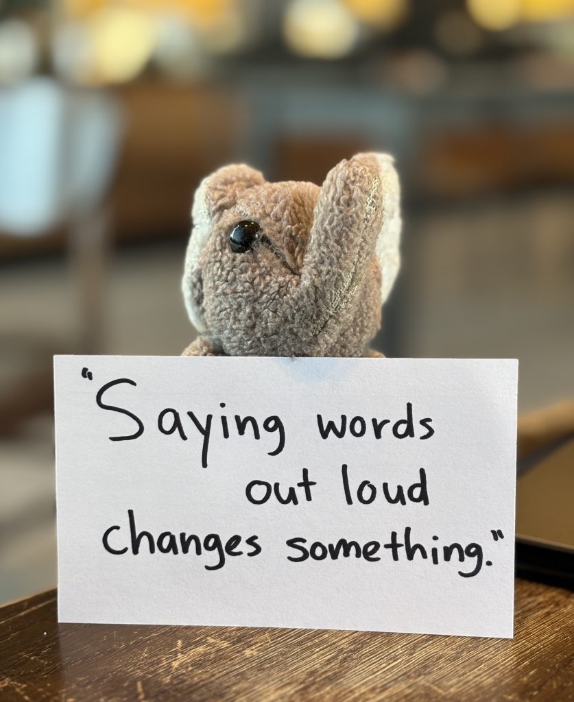 Paul holding an index card that reads: "Saying words out loud changes something."